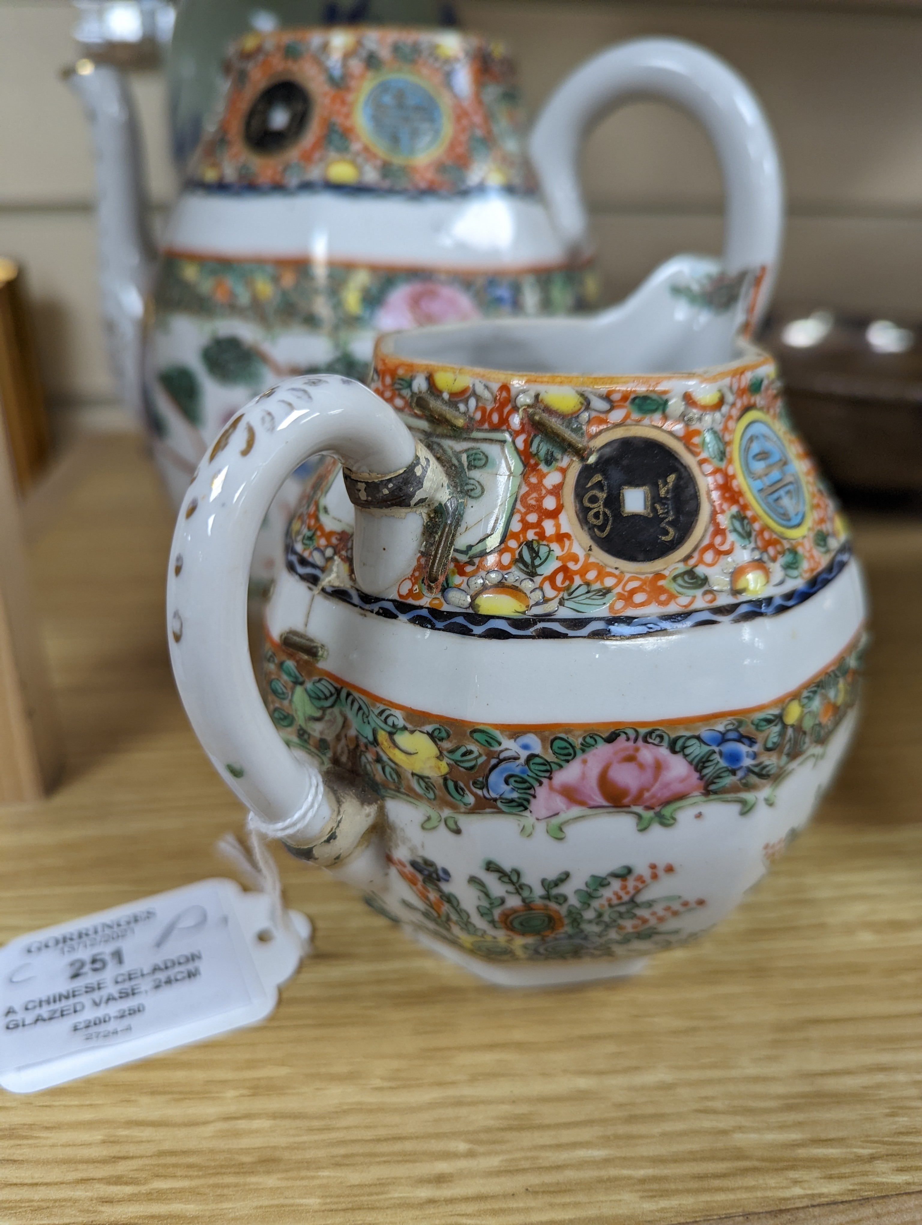 A Chinese celadon glazed vase, 24cm and a Chinese famille rose teapot and matching cream jug, a.f.